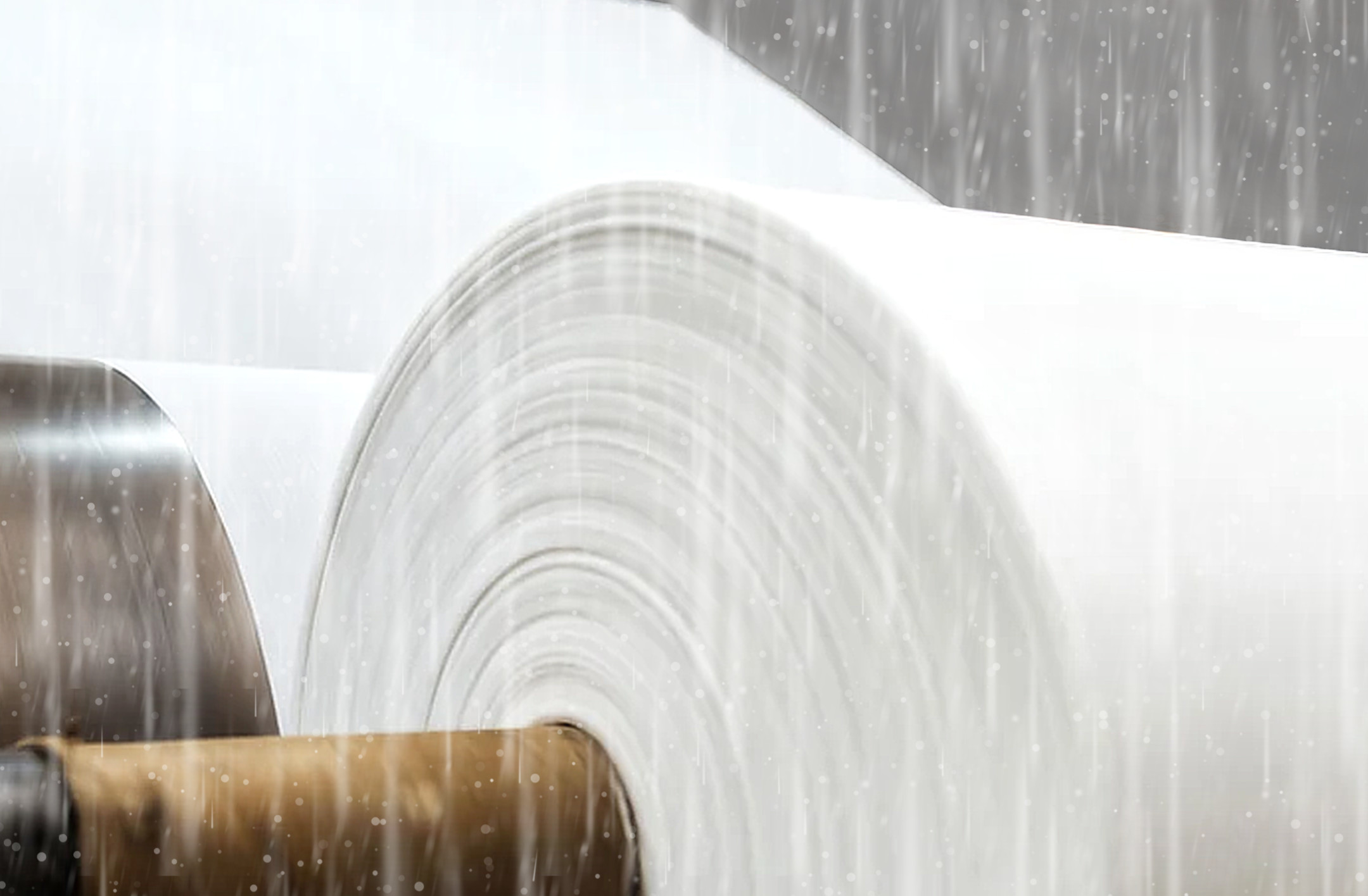 Eine Jumborolle Minero Papier im dichten Regen - so wird die Eigenschaft Wasserfestigkeit demonstriert.